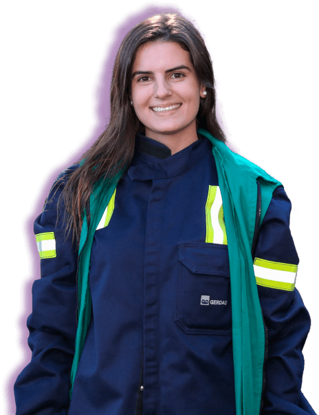 Jovem com uniforme EPI da Gerdau sorrindo para câmera